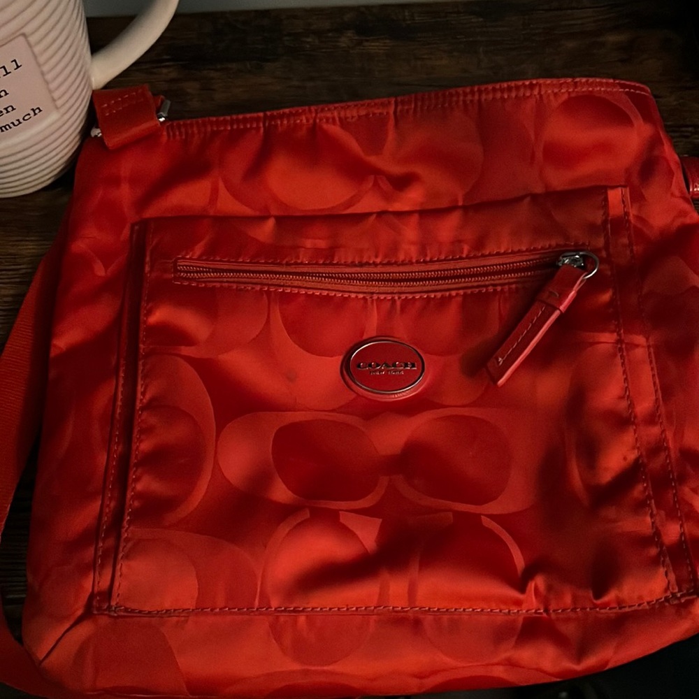 Red cloth crossbody coach bag.